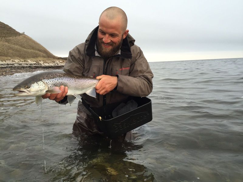Angler holding a sea trout while wearing a BasKette